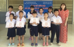 Cô giáo Bùi Thị Luân trao giấy chứng nhận cho các em học sinh gương mẫu của “Chương trình nâng cao dân trí từ gốc".
