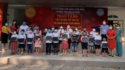 Chị Hương (thứ 2 từ phải sang) trao 23 máy tính và máy tính bảng cho học sinh Trường tiểu học Cự Khối, quận Long Biên (Hà Nội) - Ảnh: NVCC